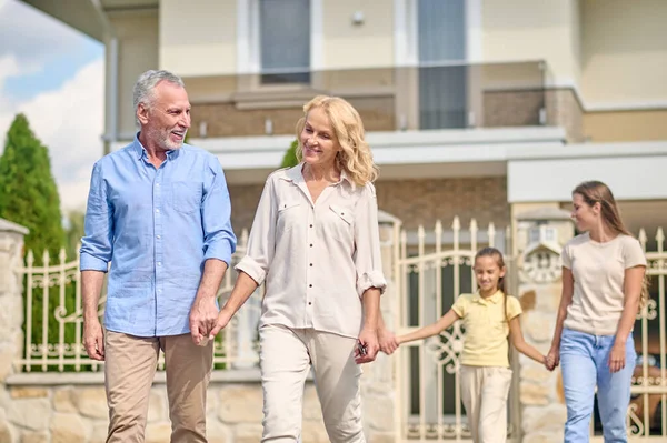 Büyük bir aile el ele yürüyor ve mutlu görünüyor.