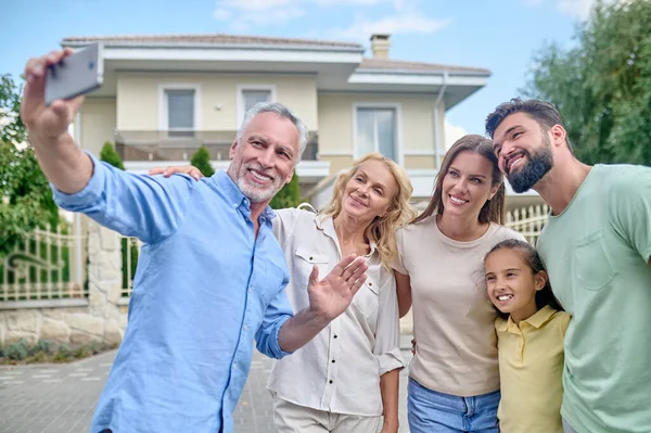 Gülümseyen bir aile sokakta film çekiyor.