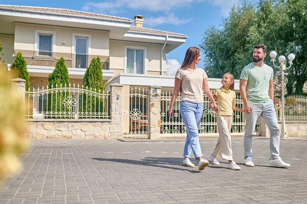 Una joven linda familia caminando por la calle — Foto de Stock