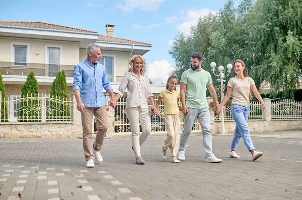 Una grande famiglia che cammina mano nella mano e sembra felice — Foto Stock