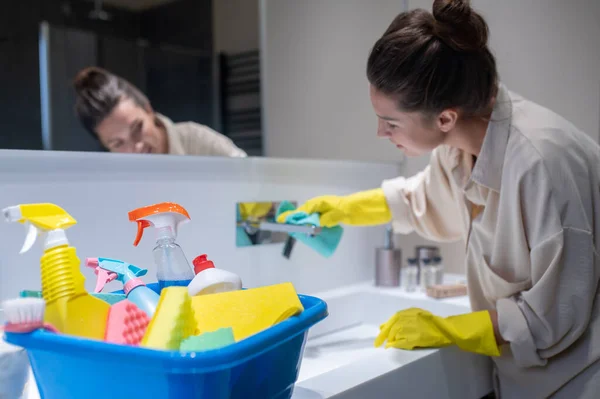 Genç bir ev hanımı banyoyu temizliyor. — Stok fotoğraf