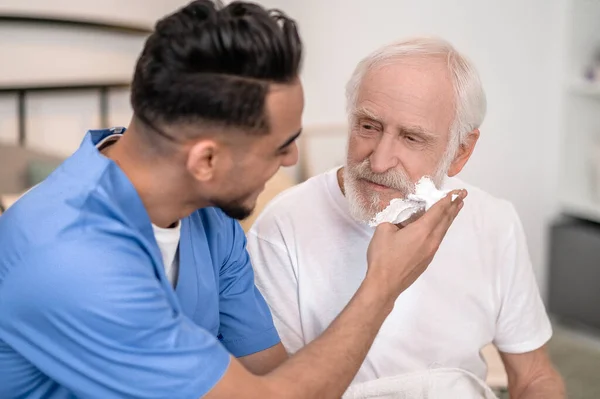 Cuidador conseguir un anciano listo para un afeitado — Foto de Stock