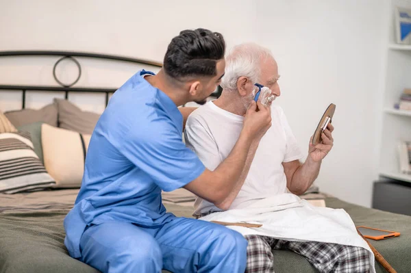 Bekçi yaşlı bir beyefendinin favorilerini kesiyor.