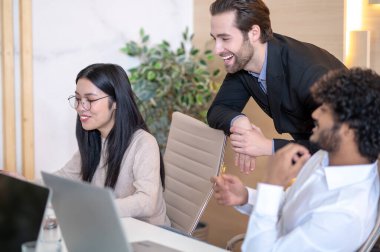 Pleased company worker demonstrating something to her coworkers