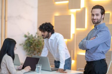 İş yerinde kameraya poz veren neşeli bir şirket çalışanı.