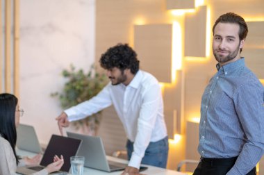 Company worker in the meeting room with his colleagues