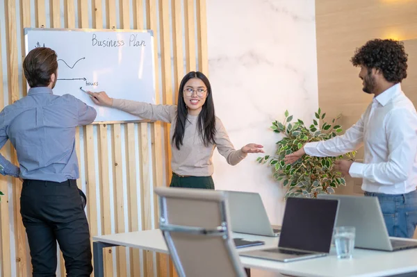 Joyous office worker discussing a business plan with her coworkers — Stock Fotó