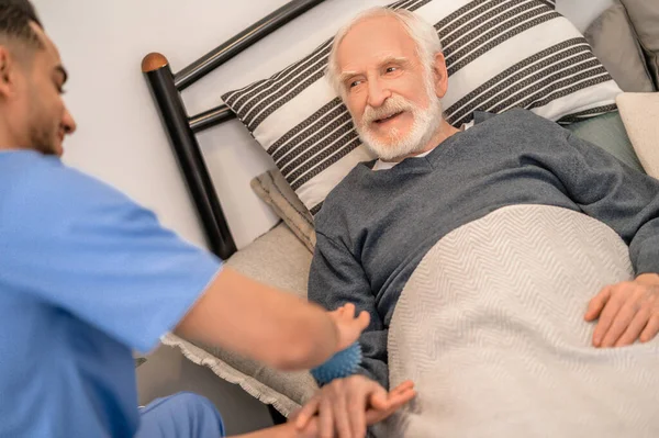 Elderly patient undergoing an in-home physical therapy session — Stock Photo, Image