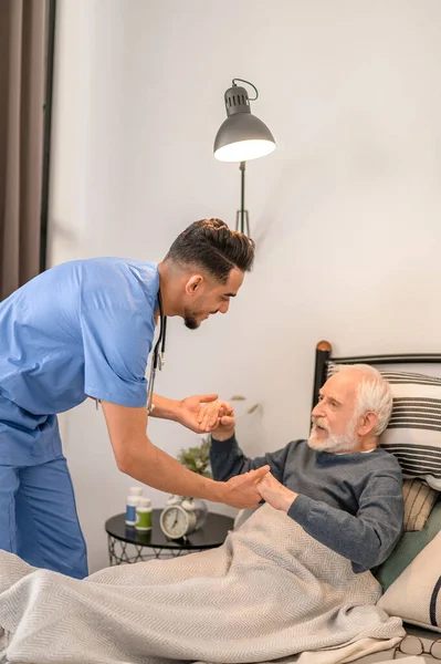 Enfermera domiciliaria asistiendo al paciente en una posición sentada — Foto de Stock