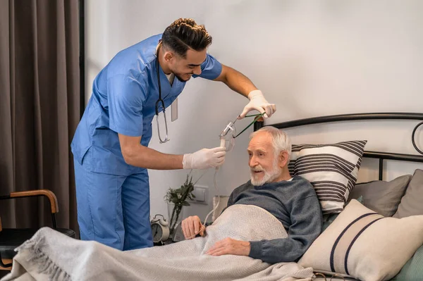Медичний працівник готує старого пацієнта до медичної процедури — стокове фото