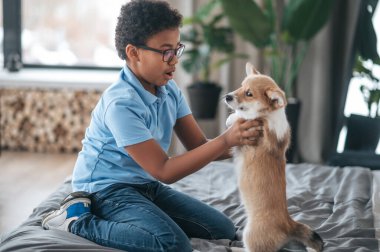 Yavru köpekle oynayan ve ilgili görünen bir çocuk.