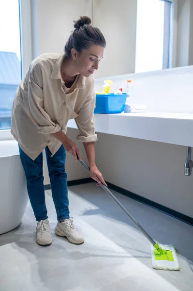 Mujer joven limpiando el suelo en casa —  Fotos de Stock