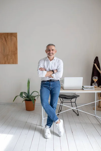 Man smiling at camera standing near table — Stockfoto