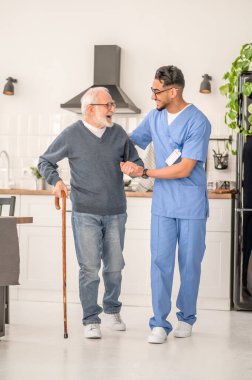 Hasta evde hemşiresinin yardımıyla mutfakta dolanıyor.