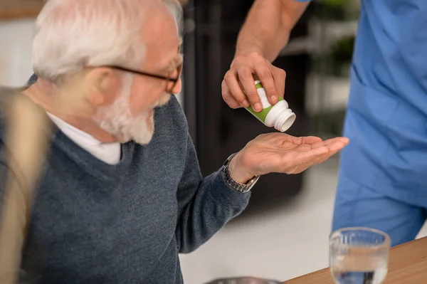 Personas mayores que reciben un medicamento del frasco de la píldora — Foto de Stock