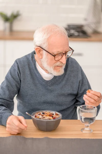 Idős ember gyógyszert szed reggelire. — Stock Fotó