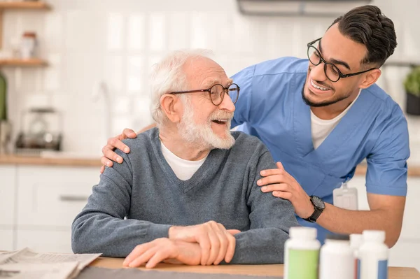 Cuidar a un trabajador sanitario que abraza a una persona mayor — Foto de Stock