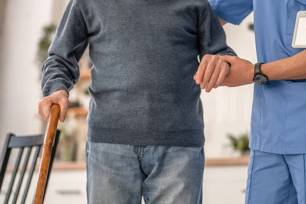 Nurse assisting a disabled person to move around the house — Stock Photo, Image