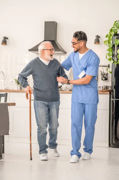 Hasta evde hemşiresinin yardımıyla mutfakta dolanıyor.