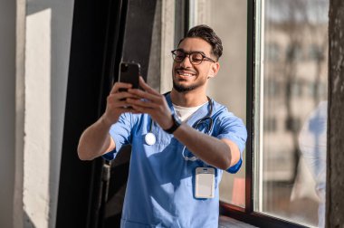 Üniformalı neşeli doktor selfie çekiyor.