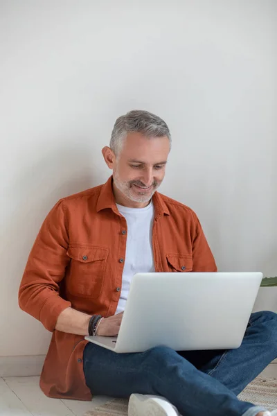 Good-looking gray-haired man working on laptop — Photo