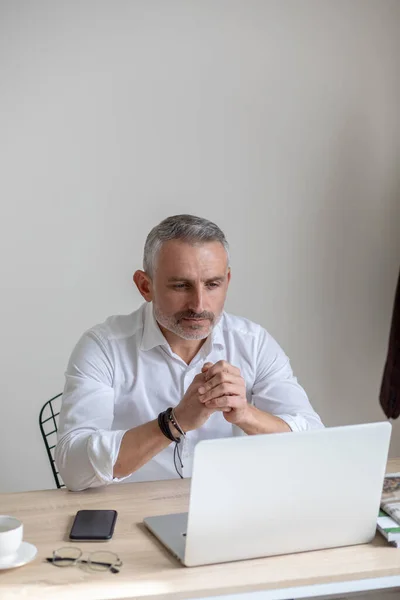 Attentive business man looking at laptop sitting at table — Stock Photo, Image