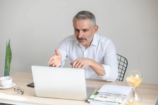 Man talking on video call looking at laptop — стоковое фото