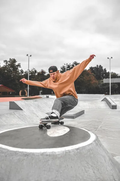 Facet na deskorolce jeżdżący na piedestale w skateparku — Zdjęcie stockowe