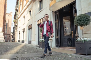 Bilgisayarlı bir adam akıllı telefondan konuşuyor.