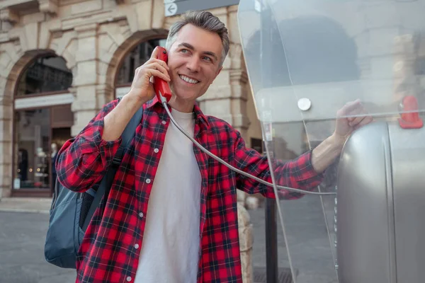 Hombre parado cerca del teléfono público en la calle —  Fotos de Stock