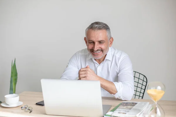 Happy man looking at laptop sitting in room — Fotografia de Stock