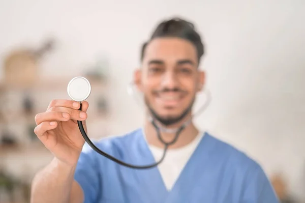 God ung allmänläkare demonstrerar sitt stetoskop — Stockfoto