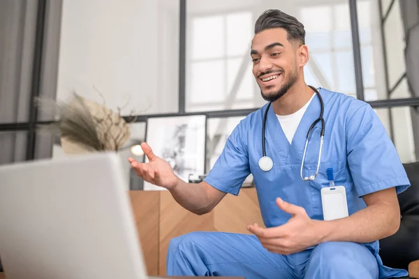 Healthcare worker communicating with his patient online — Stock Photo, Image