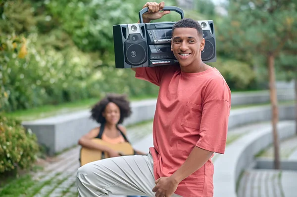 Tipo con tocadiscos en el hombro sonriendo a un lado — Foto de Stock