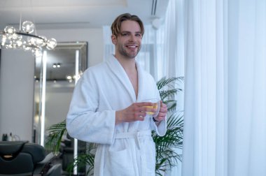 Pencereden bakıyorum. Pencerenin yanında duran beyaz cüppeli, uzun boylu genç adam.