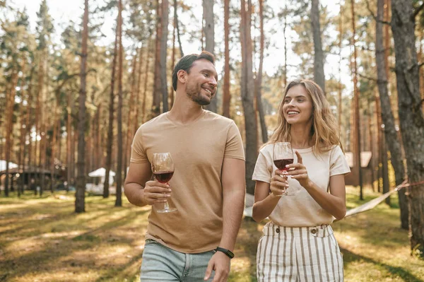 Gülümseyen Genç Beyaz Bir Çift Ellerinde Şarapla Parkta Duruyorlardı — Stok fotoğraf