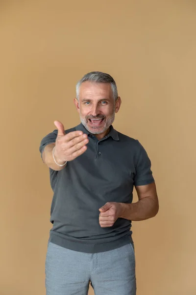 Confiança Homem Com Uma Tshirt Cinzenta Esticando Braço Para Frente — Fotografia de Stock