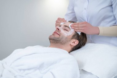 Maskeyi çıkarıyorum. Kozmetik uzmanı müşterilerin yüzlerindeki maskeyi çıkarıyor.