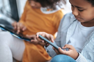 İnternette. İki çocuk internetten cihazlarını kullanıyor.