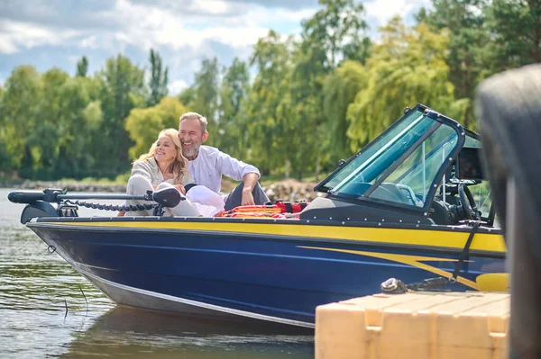 Happy weekend. A mature couple having a weekend on a river and looking happy