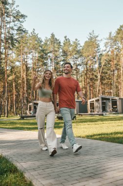 Neşeli güzel bir kadın ve parktaki taş yolda yürüyen mutlu bir genç adam.