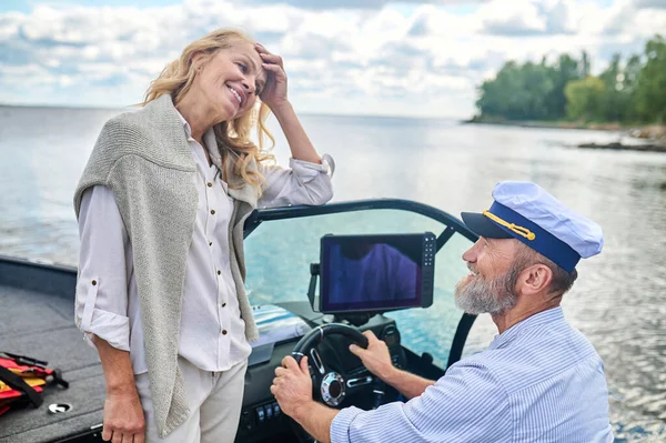 Happy moments. A mature couple sailing on a boat and looking happy