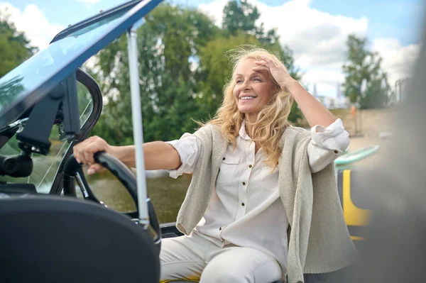 Driving. Woman holding a steering wheel of the boat and looking concentrated