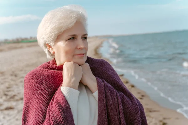 一个白发苍苍的女人站在海滨凝视着远方的画像 — 图库照片