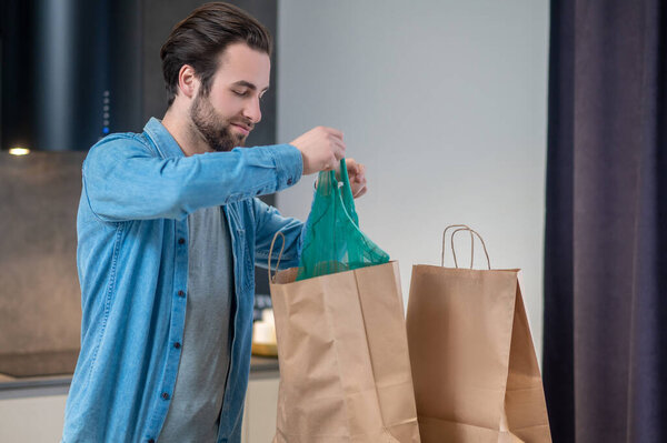 Pleasant Occupation Young Bearded Man Happily Taking Out Purchases Packages Stock Image