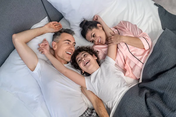 Ευτυχισμένη Οικογένεια Μια Ευτυχισμένη Οικογένεια Στο Κρεβάτι Μαζί Αναζητούν Ειρηνική — Φωτογραφία Αρχείου
