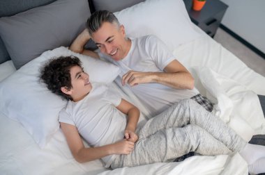 - Günaydın. Baba ve oğul sabah yatakta konuşuyor ve neşeli görünüyorlar.