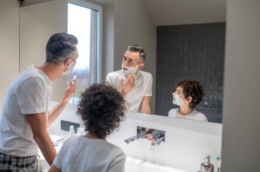 Tıraş. Baba ve oğul banyoda sabah prosedürü uyguluyorlar.