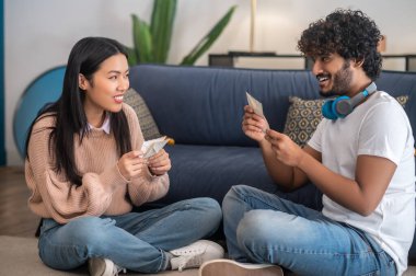 Yazışmalar. Genç insanlar ellerinde zarflarla yerde oturuyorlar.