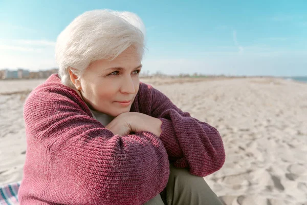 Vreedzame Dromerige Oudere Dame Zit Het Strand Kijkt Naar Iets — Stockfoto